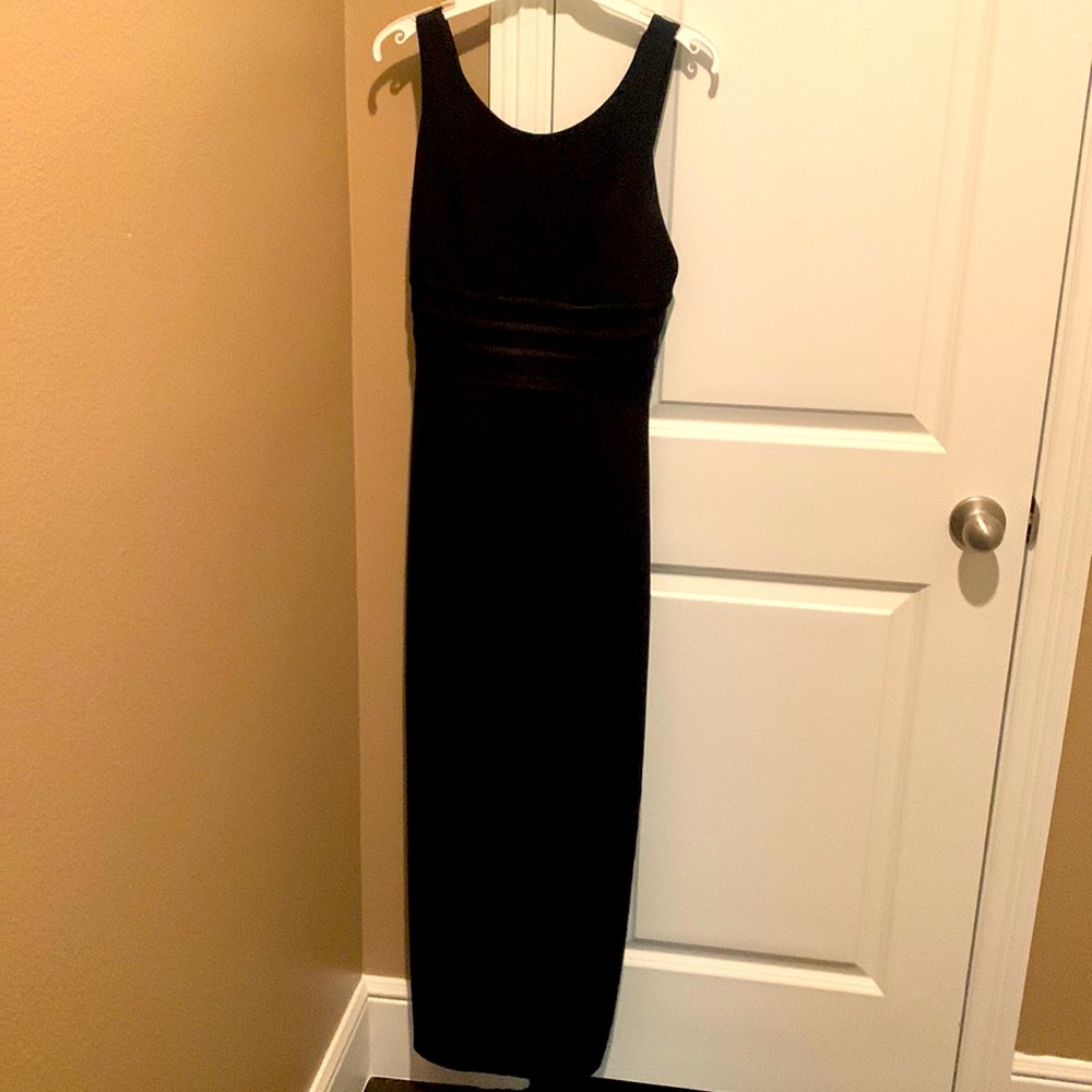 Long black column style dress strappy detailing across the bodice and the back